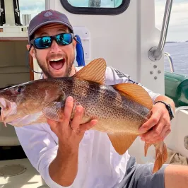 a person holding a fish on a boat
