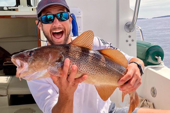 a person holding a fish on a boat