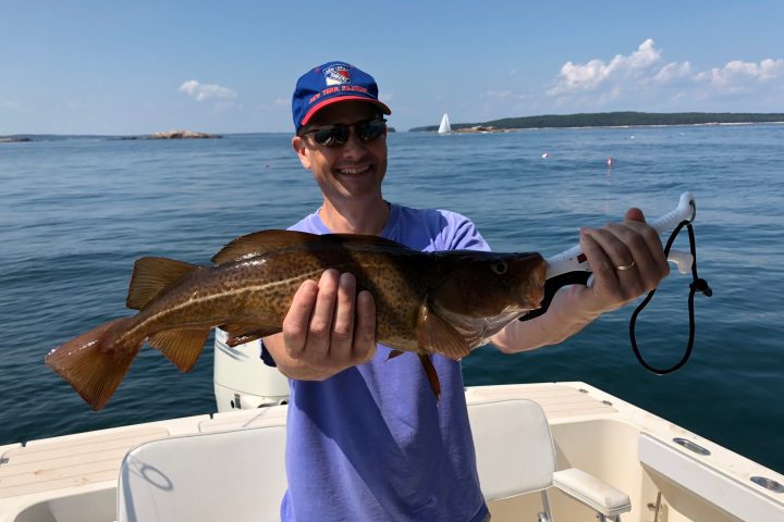 a person holding a codfish in Maine