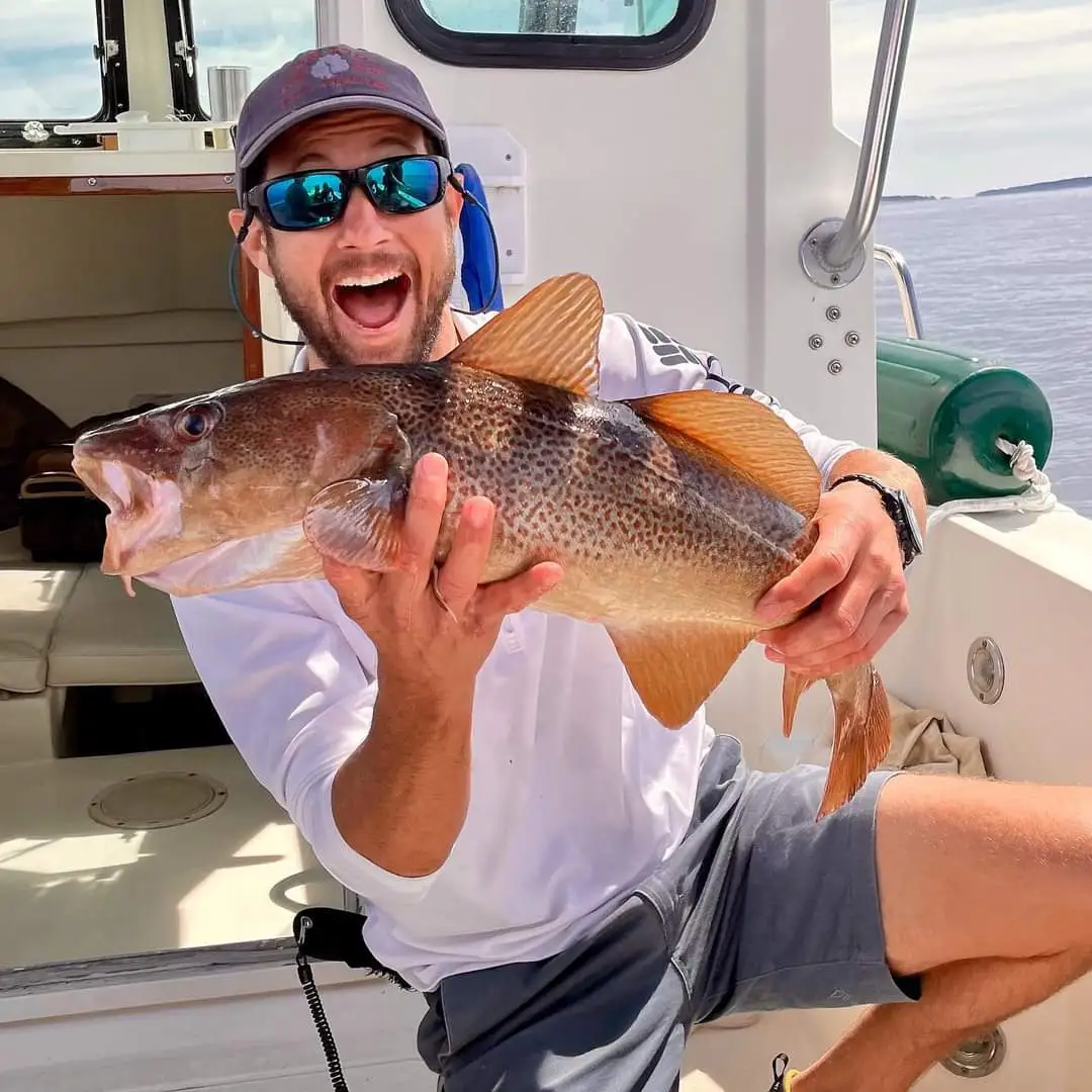 Fish Caught Captain Matt holding a fish on a boat