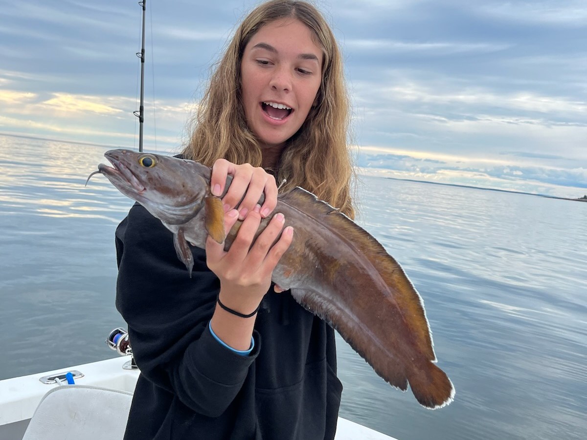 a woman holding a fish in Maine