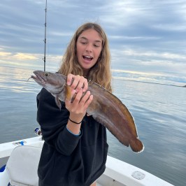 a woman holding a fish in Maine