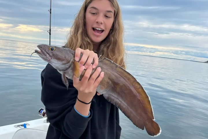 a woman holding a fish in Maine