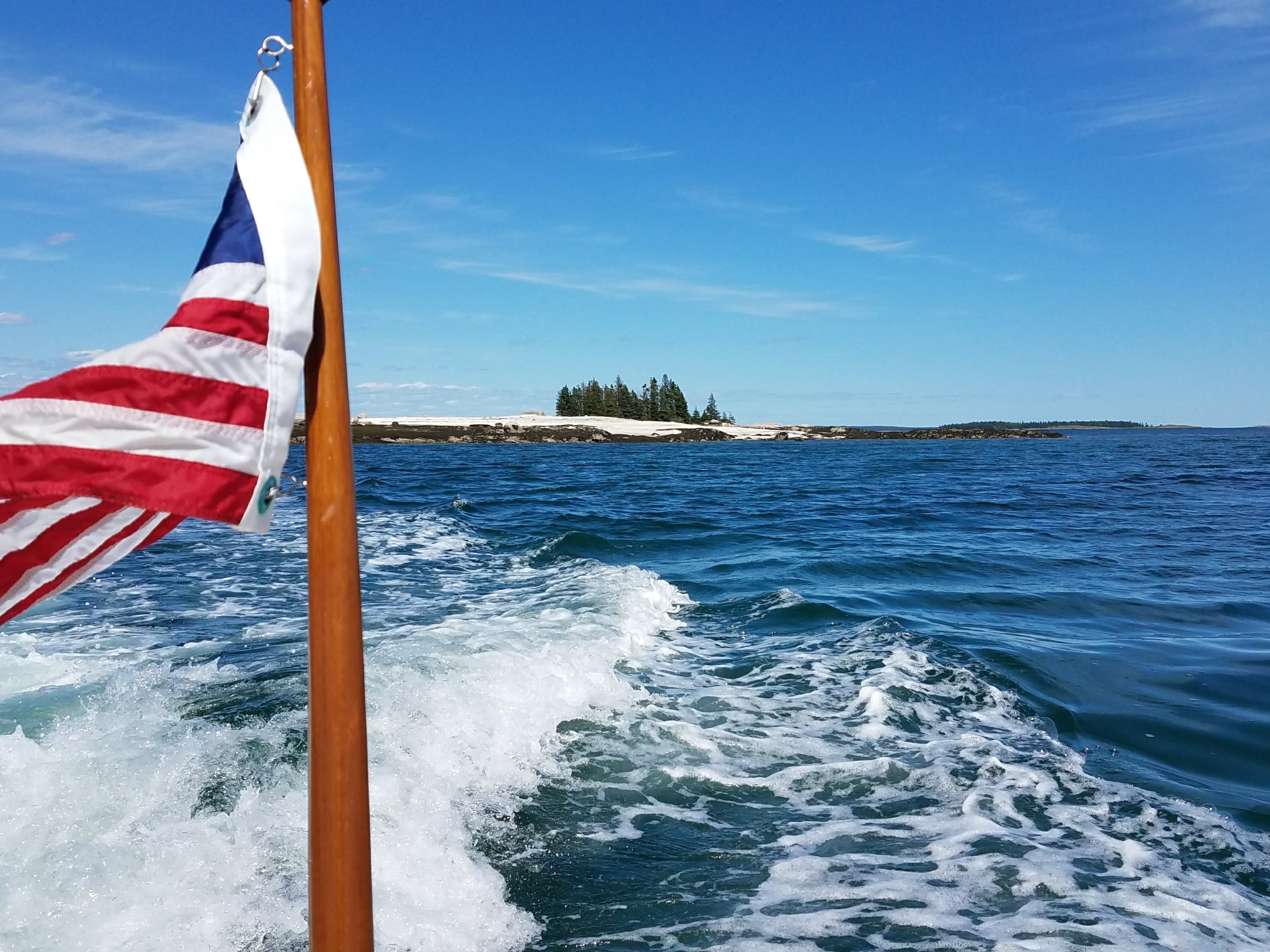 a boat with flag on a body of water
